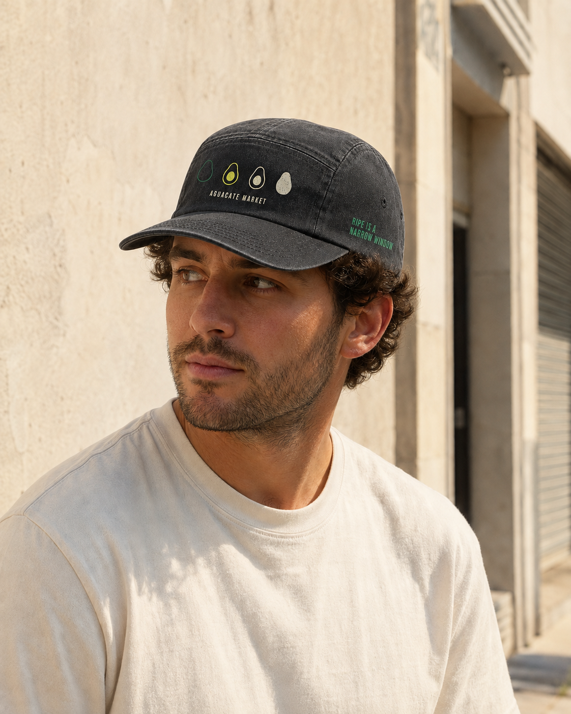 Washed black five-panel camp cap worn outdoors in afternoon sun.