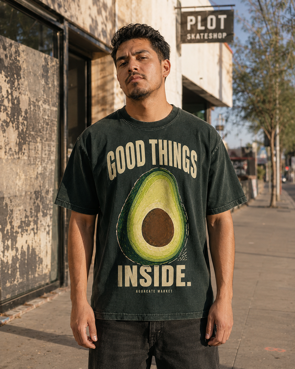 Peel green heavyweight tee worn on the street outside a skate shop, front print visible.